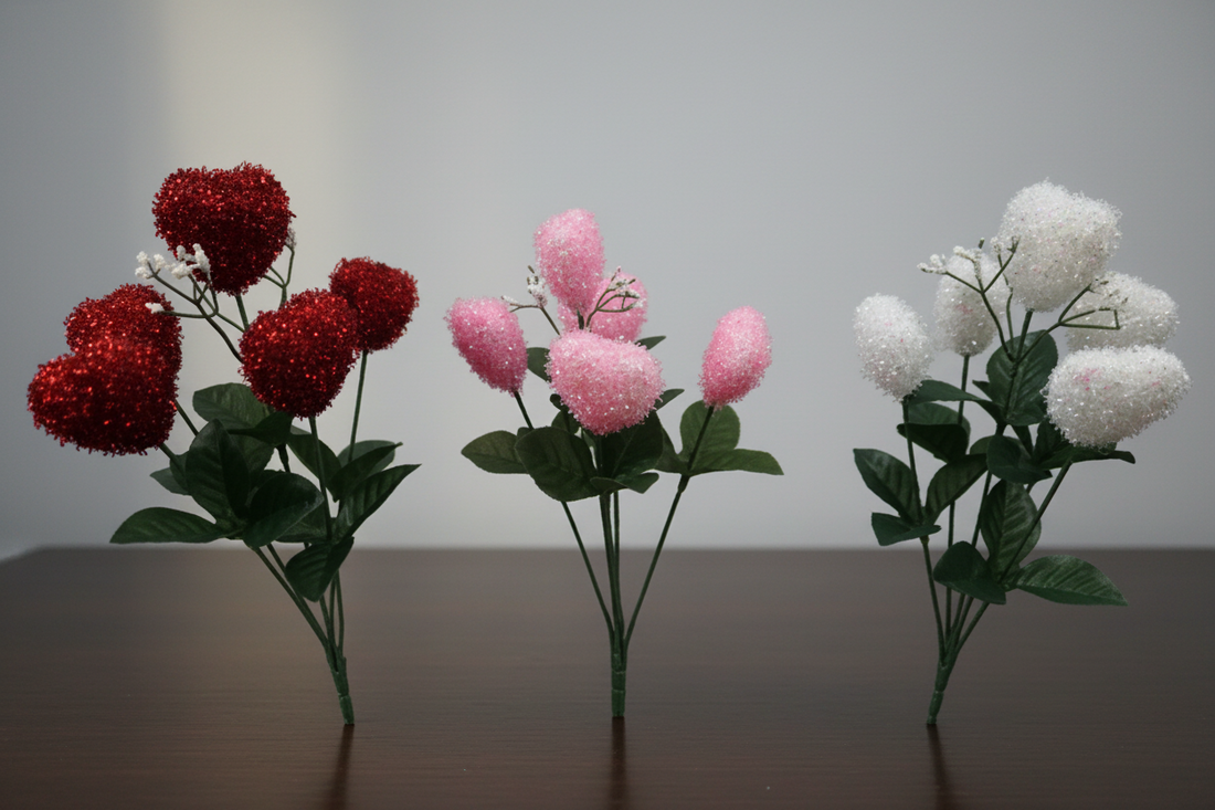 Three artificial flower arrangements in red, pink, and white on a plain background